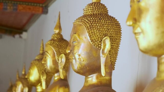 Row of golden Buddha statue in Wat Pho Temple Complex in Bangkok city, Thailand, Asia. Temple of the Reclining Buddha. Popular tourist landmark