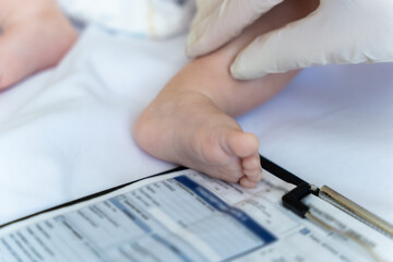 Doctor examining newborn child's feet in hospital