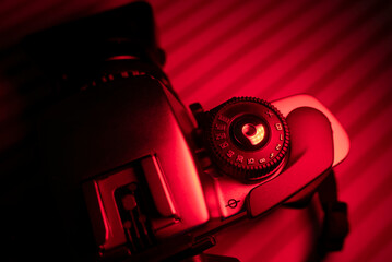 Vintage camera with lens in red light environment. Photography concept and copy space