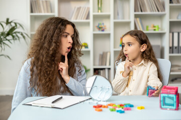 Speech therapist and her patient looking involved while doing exercises