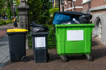 Full rubbish bins on the pavement.