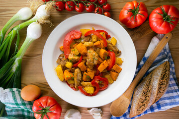 Stir-fried chicken with sweet potato and red pepper. Top view table with  decorations.