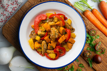 Stir-fried chicken with sweet potato and red pepper. Top view table with  decorations.
