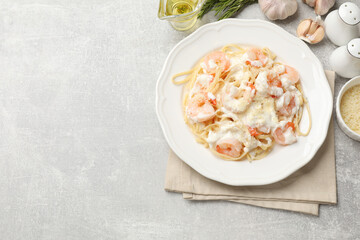 Delicious pasta with shrimps served on light table, flat lay. Space for text