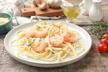 Delicious pasta with shrimps and products on wooden table, closeup