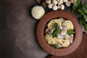 Fototapeta premium Delicious pasta with mushrooms and ingredients on brown table, flat lay. Space for text
