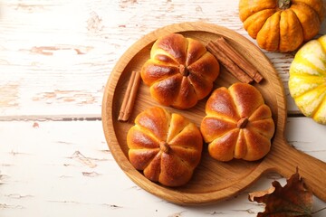 Tasty pumpkin shaped buns and ingredients on old wooden table, flat lay. Space for text