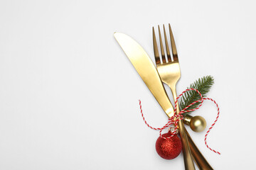 Christmas table setting. Cutlery and festive decor on white background, top view. Space for text