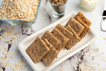 Homemade natural vegetarian and vegan oat and seed cookies on kitchen table with ingredients 