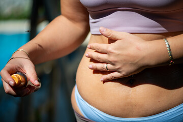Pilates Girl Spraying Tanning Oil on Her Belly