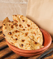 tandoori roti or bread or naan with a mockup paper bag 