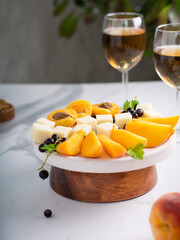 Cheese plate or board with variety of cheese, fruits and berries, nuts. Side view. Copy space