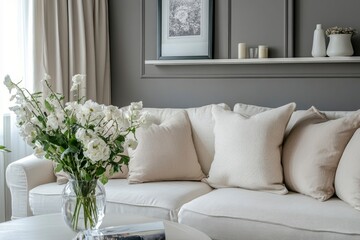 Sofa, decor on shelves, table with flowers in vase and picture on grey wall in interior of living room, ai