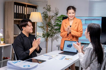 Asian businesspeople clapping after successful presentation