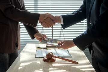 Lawyers shaking hands while exchanging bribe money after making agreement in courtroom