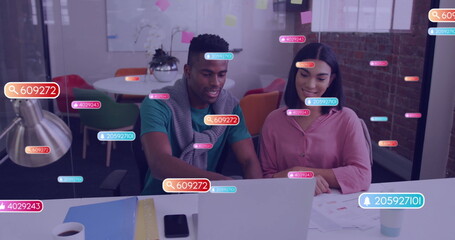 Image of social media icons with numbers over diverse colleagues discussing work in office