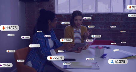 Image of social media icons with numbers over diverse colleagues discussing work in office