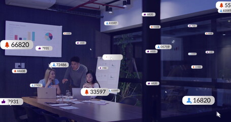 Image of social media icons with numbers over diverse colleagues discussing work in office