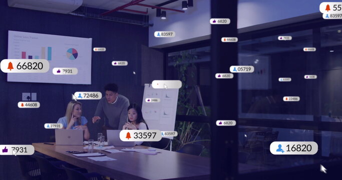 Image of social media icons with numbers over diverse colleagues discussing work in office