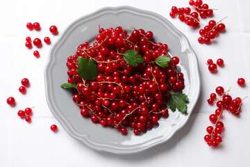 Fresh red currants and leaves on white table, flat lay