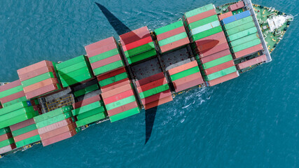 Aerial view container cargo ship at sea with airplane shadow. Global trade and logistics concept....