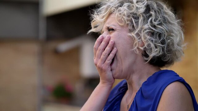 A young woman in a blue dress with short blonde curly hair yawning from boredom. The scene reflects her disinterest and tiredness.