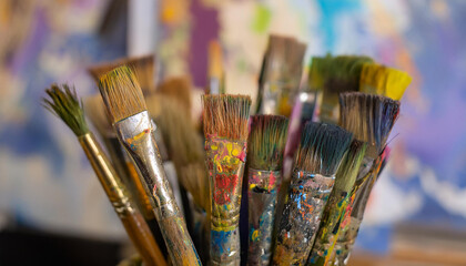 Fototapeta premium Well-used paint brushes with traces of colorful paint. Wet paint. Hobby and leisure concept.