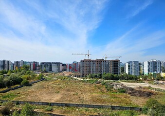 construction site with crane and building, unfinished building. Construction of a residential high-rise building with apartments and parking. Cranes on pouring concrete in formwork.