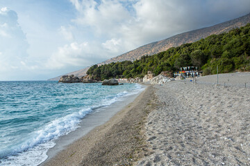 Very beautiful coastline on the Ionian Sea in Albania. The beach with fine sand in the mountains of Albania. Vacation at the sea.