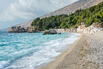 Very beautiful coastline on the Ionian Sea in Albania. The beach with fine sand in the mountains of Albania. Vacation at the sea.