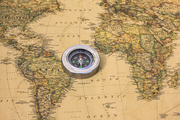 Classic round compass on background of old vintage map