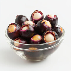 Obraz premium Fresh mangosteen fruits are displayed in clear glass bowl, showcasing their unique purple exterior and creamy white flesh. This vibrant arrangement highlights fruits exotic appeal and freshness