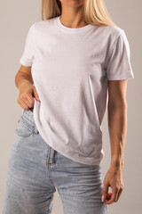 Obraz premium Blonde girl posing on white background in white t-shirt and denim shorts