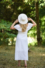 Fototapeta premium Closeup back view of woman in white hat looking out towards .