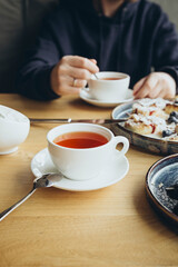 A man drinks tea in a cafe during breakfast, the concept of a sweet breakfast.