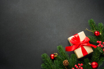 Christmas present with holiday decorations on black with copy space. Black Christmas flat lay background for your design.
