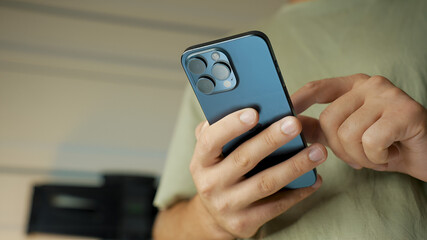 a man is holding a blue smartphone