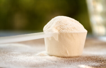 A scoop of collagen powder on a table outdoors