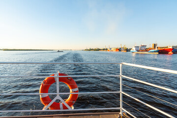 a lifebuoy suspended from the stern rail of the vessel against the background of a trace on the...