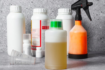 Several plastic jars with pesticides on the table.