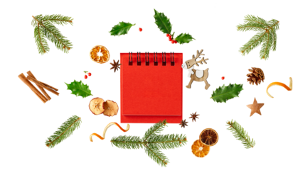 Blank red desk calendar with Christmas decor. Fir branches, holly berry, pine cone, dried apple and orange slices, cinnamon sticks, anis stars isolated on white