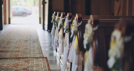 Empty church aisle decorated with flowers for wedding ceremony