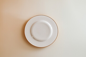 Ceramic white flat plate for food on white table top view