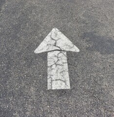 A close view of the white arrow on the pavement.
