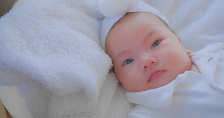 Adorable Newborn Baby with White Headband Resting on Soft Blanket, Close-Up Portrait Capturing Innocence and Serenity, Perfect for Parenting, Family, and Baby Care Themes