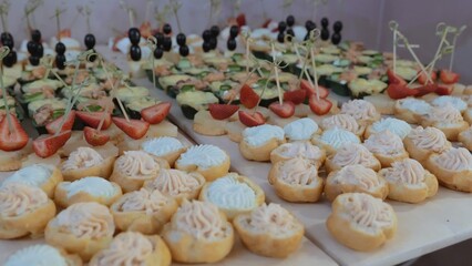 Catering on a banquet table with appetizers-canapes in a restaurant or hotel. Snacks on the table, catering concept. buffet food set for corporate day celebration.
