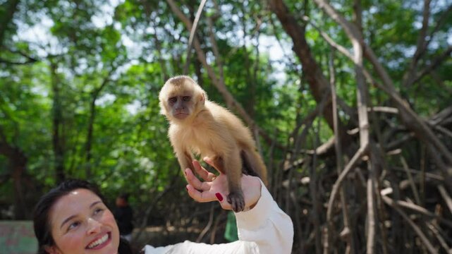 Travel woman posing for photo with monkey sitting on shoulder at Brazil, playful monkeys sharing wildlife adventure
