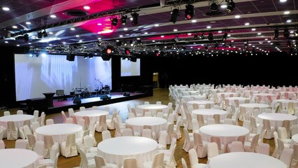 Aerial drone flyover of an conference hall with dinner tables ready for an event