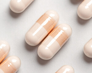 Close-up of beige capsules on a white background