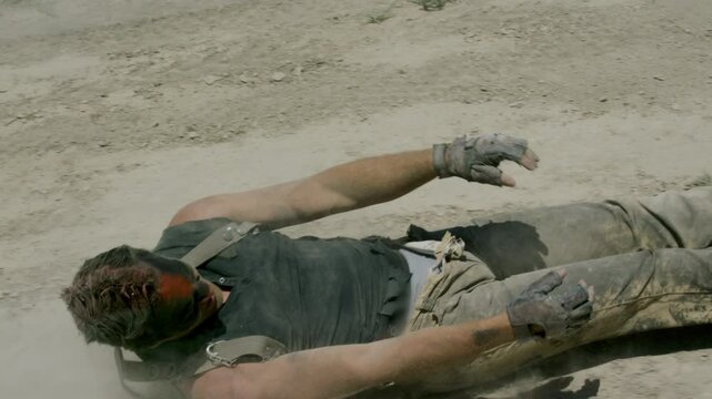 Epic stunt of post-apocalyptic survivor being dragged in dirt